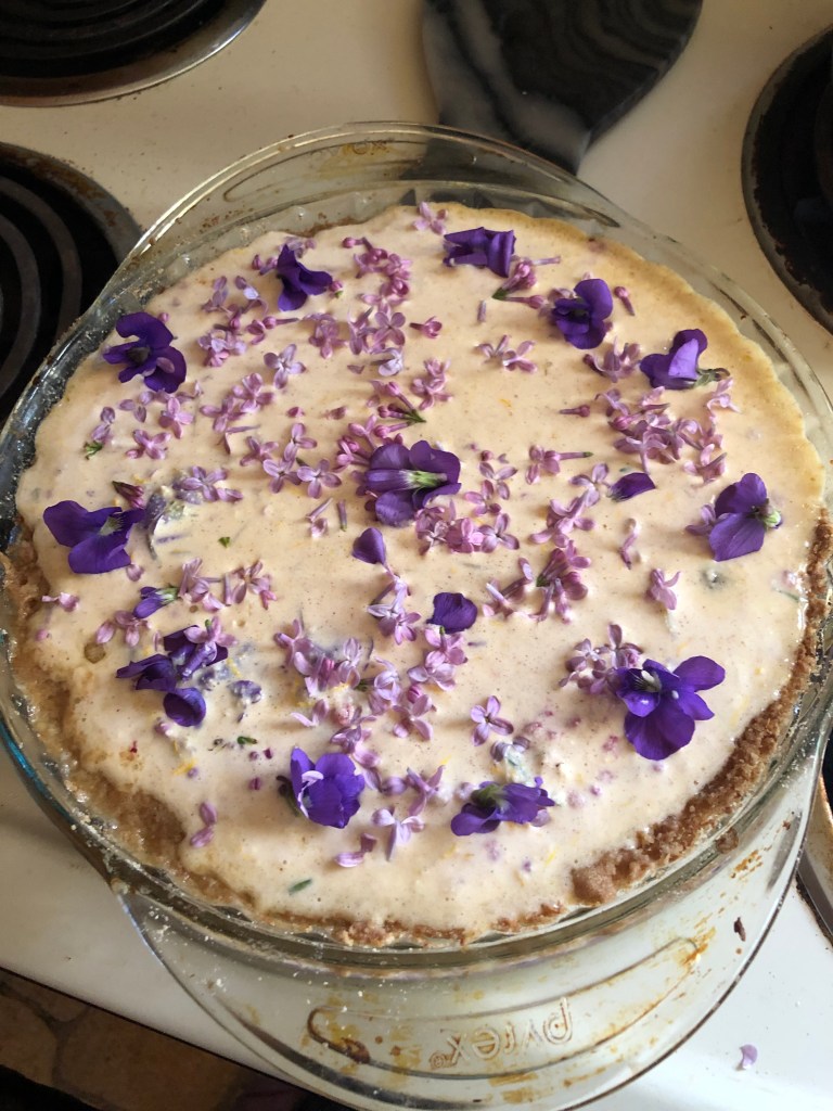 Fruit Kuchen with Violet and Lilac flowers as part of a custard topping about to go into the oven. 
